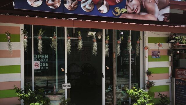 Chana Massage shop entrance with potted plants, striped walls, and a sign showing relaxing massage images above the door.