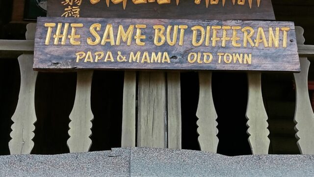 A wooden sign reads, THE SAME BUT DIFFRANT PAPA & MAMA OLD TOWN with text in Thai and Chinese above.