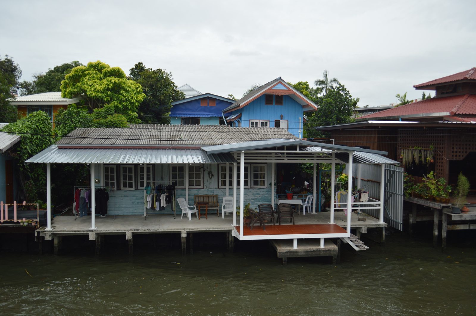 Traditional wooden Thai stilt houses along a quiet riverside